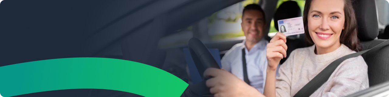 Uśmiechnięta młoda kobieta odbierająca prawo jazdy w samochodzie egzaminacyjnym po zdanym egzaminie państwowym 2026